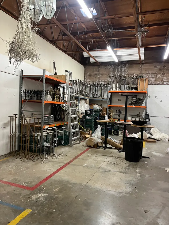Warehouse bay with shelving, metal stands and junk before a commercial cleanout